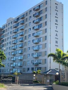 a large white building with palm trees in front of it at Santana in Margate