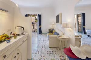 Antica Rheginna Luxury Room في مينوري: مطبخ وغرفة معيشة مع طاولة وأريكة