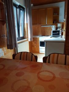 y cocina con mesa, sillas y fogones. en Apartments Gregorc en Bled