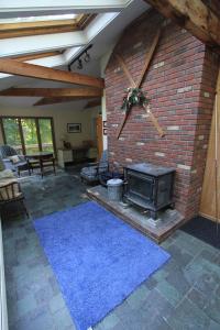 a living room with a brick fireplace and a stove at Quaint Stowe Cabin in Stowe