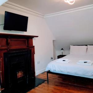 a bedroom with a bed with a fireplace and a flat screen tv at Ness City Cottage in Inverness +6 photos