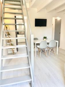濱海拉塞訥的住宿－Appartement à 150 m de la mer，梯子通往带桌椅的客厅