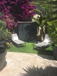 a garden with two lounge chairs and pink flowers at STUDIO TOUT A PIEDS in Sanary-sur-Mer +9 photos