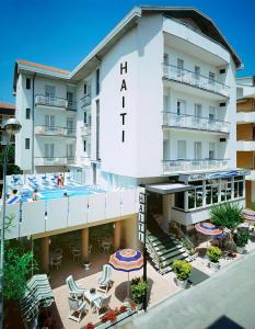 un hotel con piscina, mesas y sillas en Hotel Haiti, en Cattolica