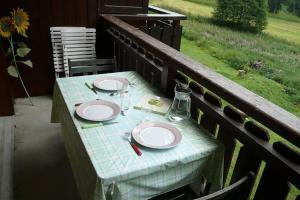 un tavolo con piatti e bicchieri da vino su un portico di Les Chalets du Pounant - Alpes du Léman a Bellevaux
