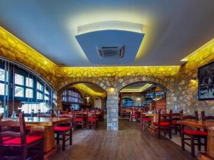 a restaurant with wooden tables and red chairs at Eco-selo Grabovica in Grabovica
