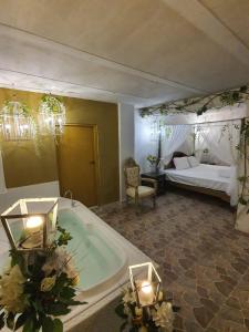 a large bathroom with a tub and a bed at HOTEL BOUTIQUE EL FARO BY AROMAX in Medellín