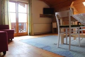 Zimmer mit einem Stuhl und einem Wohnzimmer mit einem Fenster in der Unterkunft Ferienwohnung Johanna in Bad Goisern