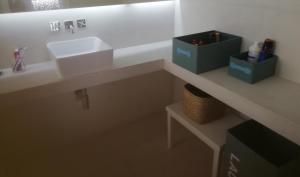 a bathroom with a sink and two boxes on a counter at Casa do Jardim in Beja