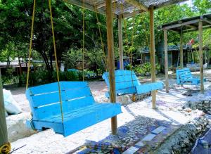 two blue benches sitting on a swing in a park at El Hamaquero Hostal EcoNativo in Isla Grande