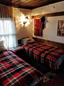 een slaapkamer met een bed en een geruite deken bij Къщата на художника in Zheravna