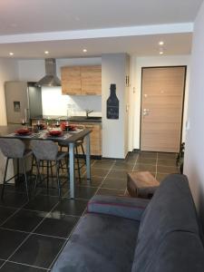 a living room and kitchen with a table and chairs at Le Riesling Colmar centre Charmant appartement avec terrasse et parking gratuit in Colmar
