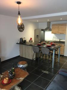 cocina con mesa, sillas y barra en Le Riesling Colmar All inclusive Free parking, en Colmar