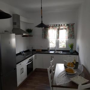 uma cozinha com uma mesa, um frigorífico e uma janela em Casa Lela I em Fuencaliente de la Palma