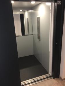 a glass shower door in a room with a mirror at Le Riesling Colmar centre Charmant appartement avec terrasse et parking gratuit in Colmar