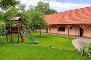 einen Spielplatz in einem Hof neben einem Gebäude in der Unterkunft Kishíd Vendégház Pilismarót in Pilismarót