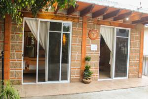 una casa de ladrillo con 2 puertas correderas de cristal en Hospedaje Piedra de Sol, en Tepoztlán