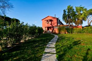 a path in front of a house with a building at Proprietà Scalfati in Sabaudia