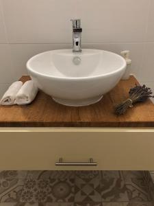 a white sink on a wooden counter with towels at Borbély apartman in Nagykanizsa