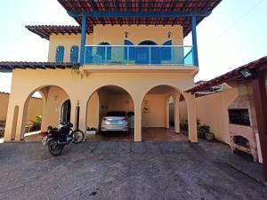 ein Haus mit einem Motorrad, das davor geparkt ist in der Unterkunft Casa da Edna in Guarujá