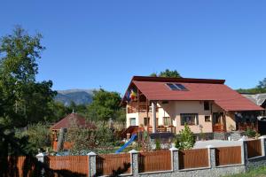 une maison avec un toit rouge derrière une clôture dans l'établissement Arnota, à Costeşti