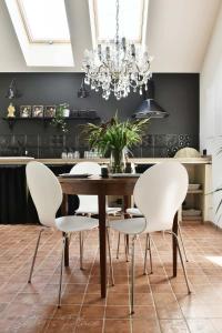 a dining room with a wooden table and white chairs at Betty's Place in Zabierzów