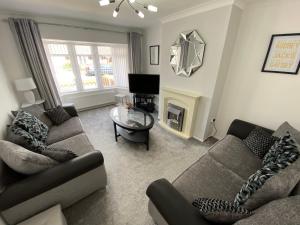sala de estar con 2 sofás y TV en COLERIDGE LODGE, en Thornton