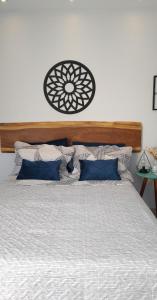 1 cama con cabecero de madera y almohadas azules en Loft para temporada, en Cabo Frío