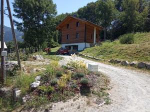 una casa en una colina con un camino de tierra en Appartement 25m2 à Saint-Gervais les bains, en Saint-Gervais-les-Bains