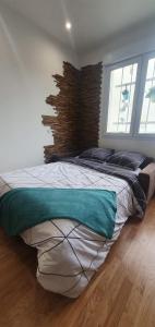 een slaapkamer met een groot bed met een bakstenen muur bij Le Paon chaleureux et calme entre Paris et Disneyland in Ozoir-la-Ferrière