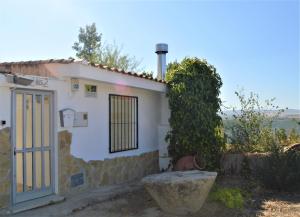 a small white house with a door and a window at Casa Rural Consuelo in Alcalá del Júcar