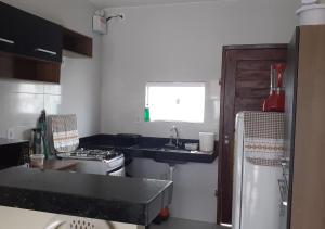 cocina pequeña con fregadero y fogones en Casa Serena Jacumã en Jacumã