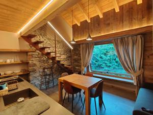 a dining room with a table and a large window at Au Fond du Bourg VDA Jovencan 0001 - 0002 in Aosta
