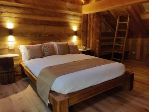a bedroom with a bed in a wooden cabin at Au Fond du Bourg in Aosta