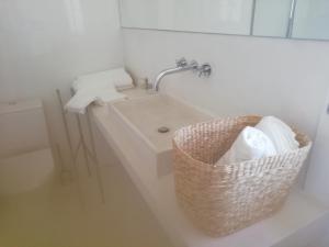 a bathroom with a basket next to a sink at Casa do Jardim in Beja
