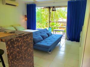 uma sala de estar com um sofá azul e cortinas azuis em Bangalô Villas do Pratagy com jacuzzi em Maceió