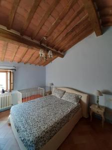 a bedroom with a bed and a wooden ceiling at Al Piccolo Ulivo, a casa di Mimo&Sè in Castiglione dʼOrcia