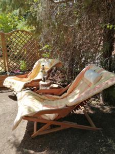 two lounge chairs sitting on the ground next to a bench at La casa del Duero in Tordesillas