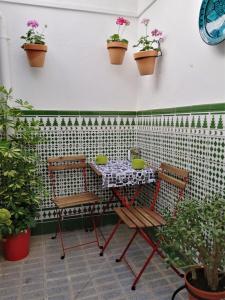 un patio con tavolo, sedie e piante in vaso di Casa de La Costurera a Priego de Córdoba