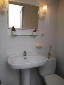 a bathroom with a sink and a toilet and a mirror at Casa de La Costurera in Priego de Córdoba
