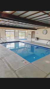a large swimming pool with a clock on the wall at Super 8 by Wyndham Watertown WI in Watertown