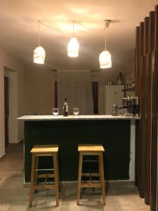 a kitchen with a green counter and two stools at Finca La Vega in Zamora