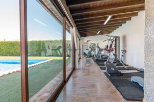 un gimnasio cubierto con máquinas de correr y una piscina en Villa Charme en Pêra