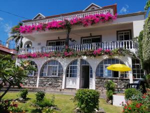 ein Haus mit rosa Blumen auf dem Balkon in der Unterkunft Apartments Vista Oceano in Funchal