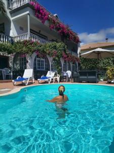 un hombre en una piscina en una casa en Apartments Vista Oceano, en Funchal