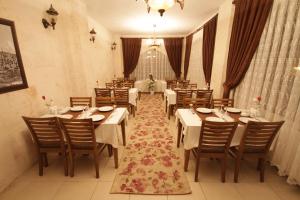 a dining room with white tables and chairs at Zinciriye Hotel in Mardin