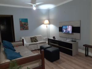 a living room with a couch and a flat screen tv at Linda casa Rio das Ostras in Rio das Ostras