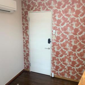 a door in a room with a flower patterned wall at Guesthouse Zink in Sado