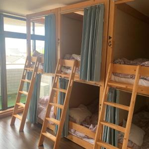 4 łóżka piętrowe w pokoju z oknem w obiekcie Guesthouse Zink w mieście Sado