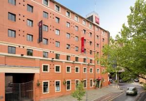 a large red brick building on a city street at Ibis Sheffield City in Sheffield